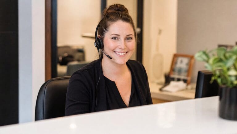 Front desk receptionist using AI front desk software at a reception desk