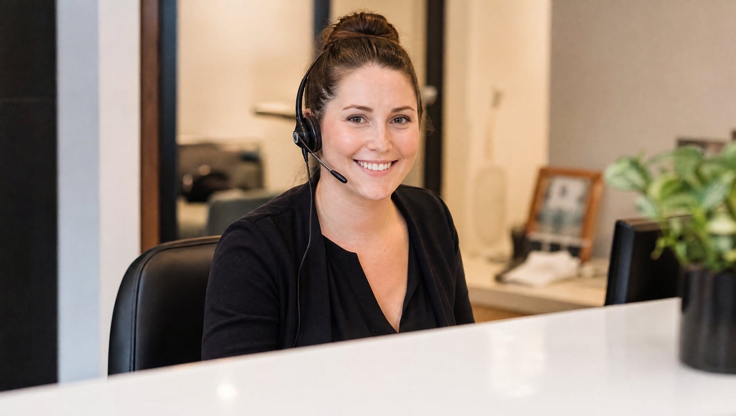 Front desk receptionist using AI front desk software at a reception desk