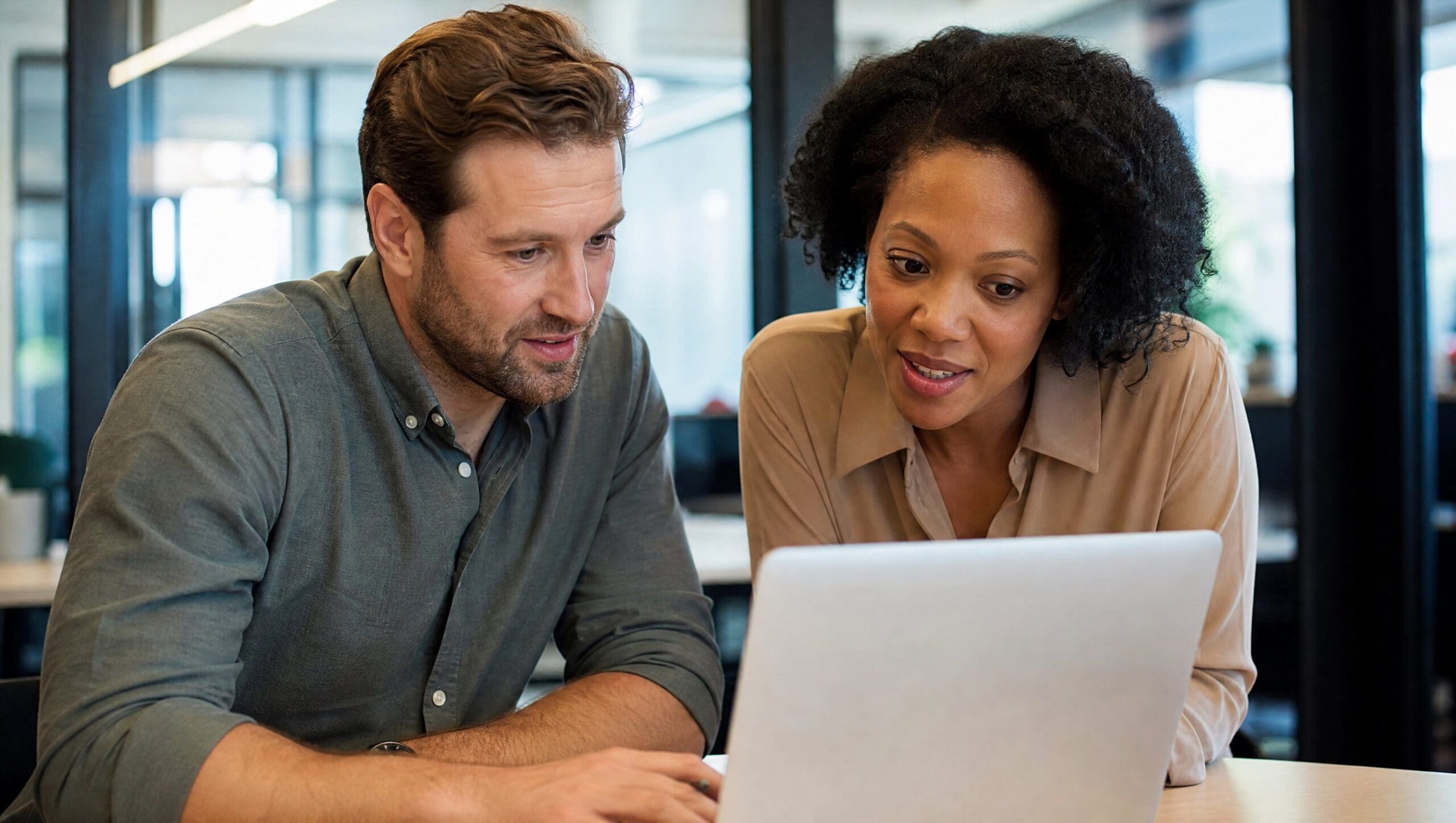 Two B2B colleagues booking a meeting with AI scheduling tools on a laptop