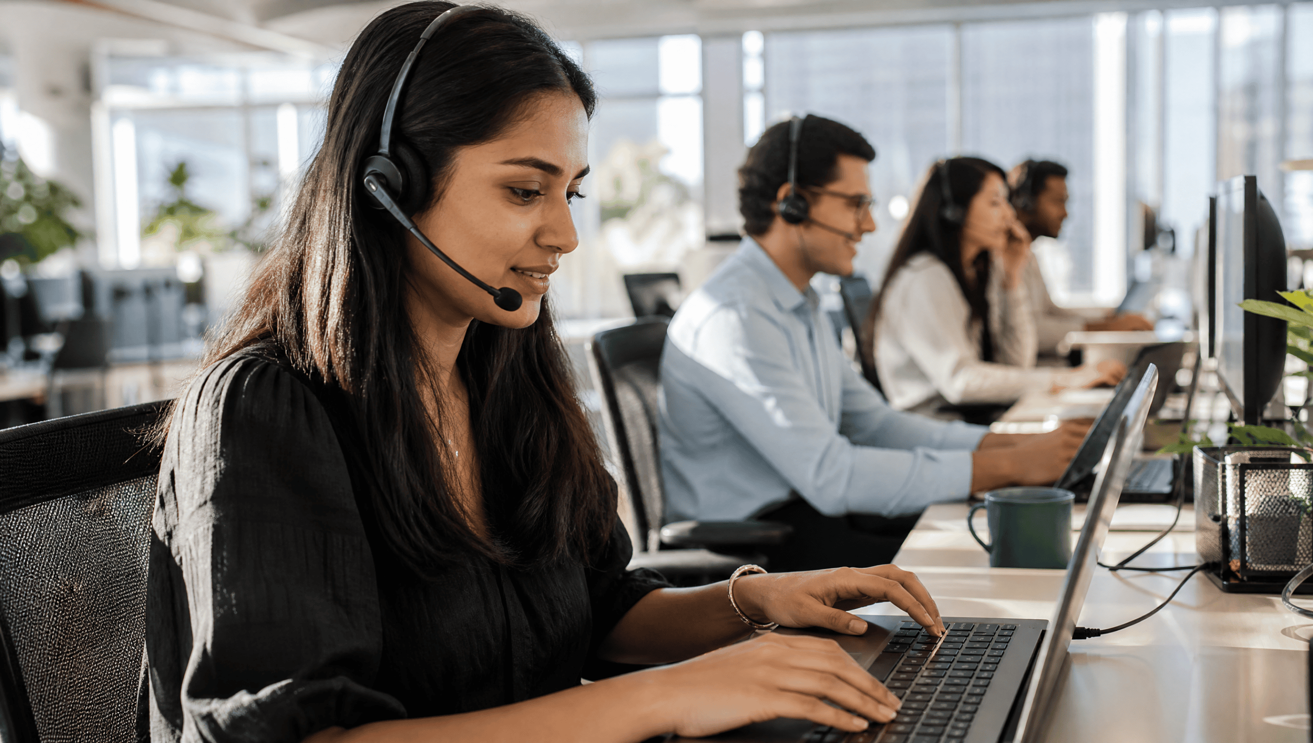 Diverse team of sales reps on outbound calls in a bright office