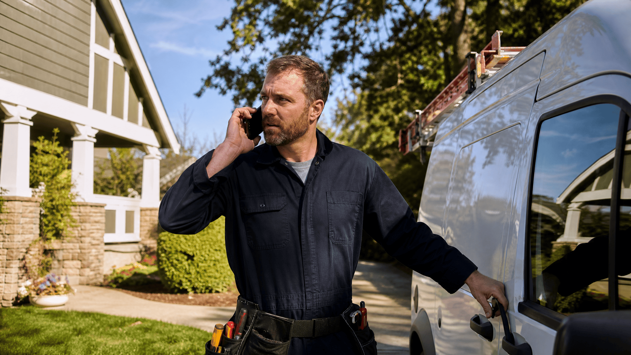 Plumber taking an AI-routed emergency call outside a residential job site