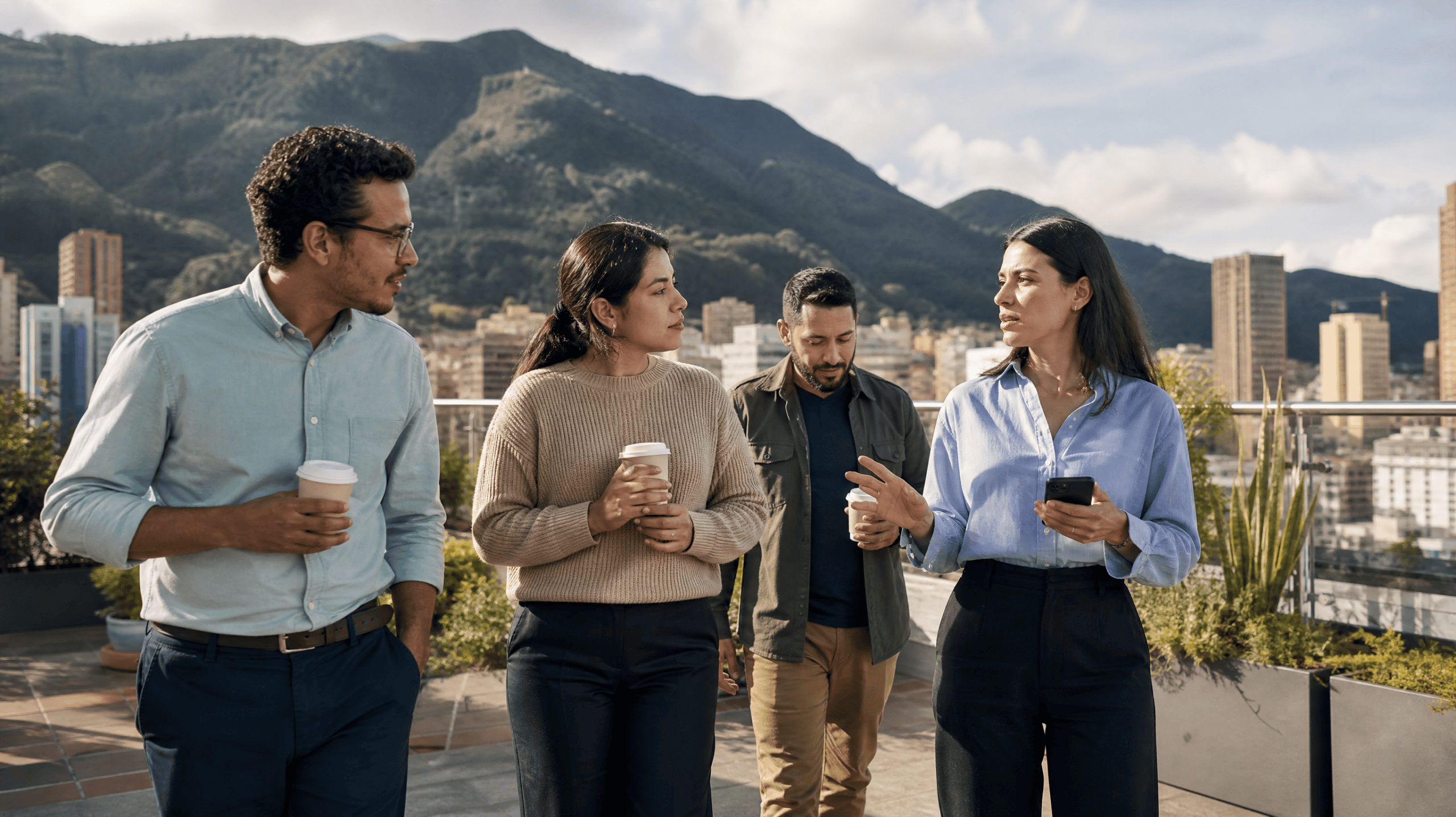 Equipo de profesionales en una terraza en Bogotá con las montañas al fondo