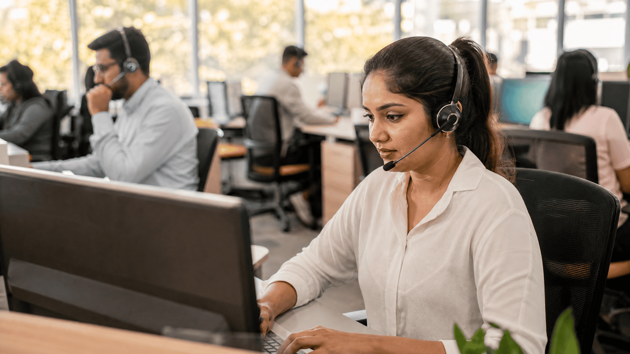 Piso de call center moderno con agentes con auriculares
